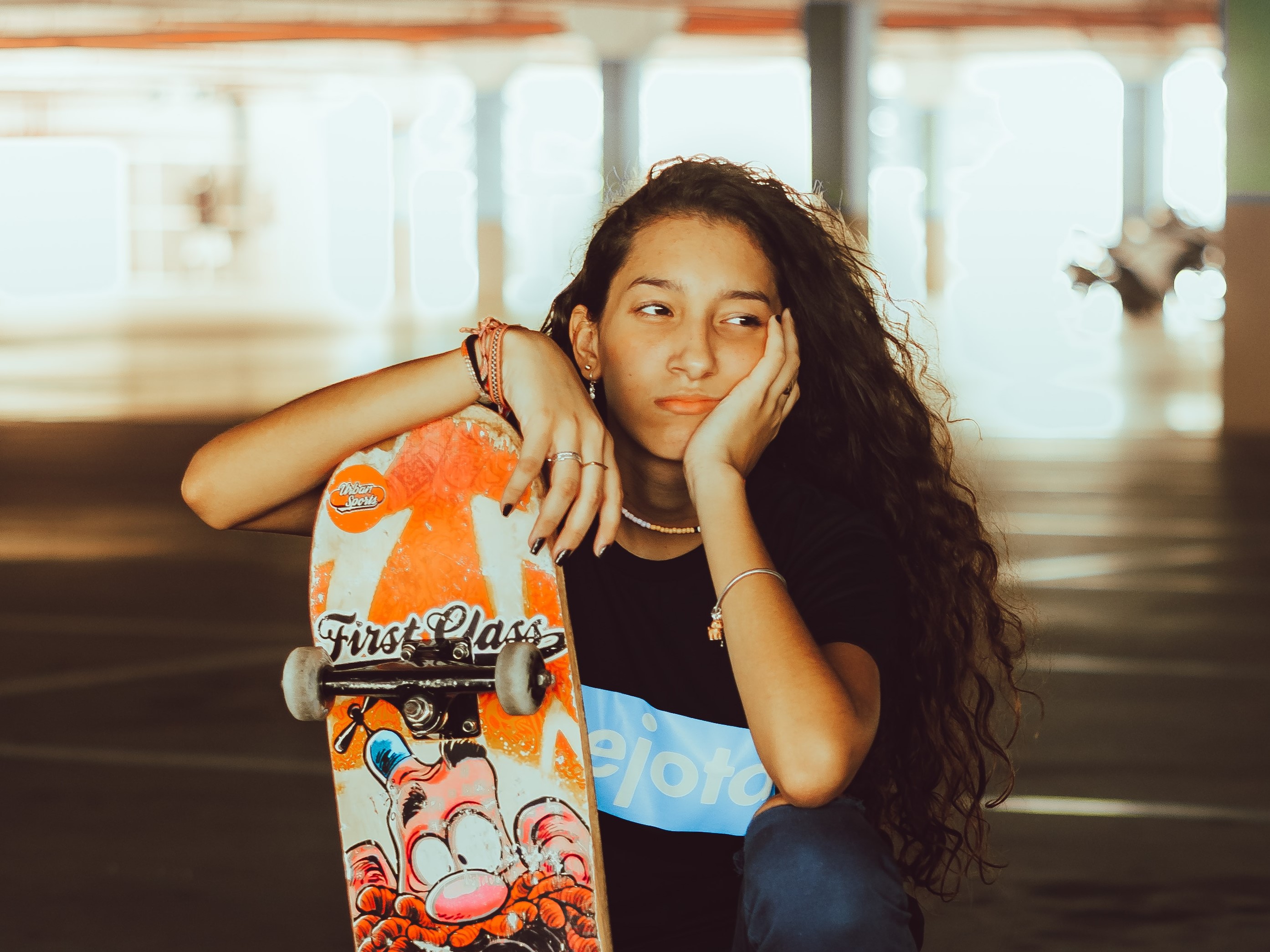 Portret tienermeisje met lang bruin haar en skateboard